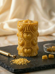 candle with heart designs on a dark surface with honeycomb and 