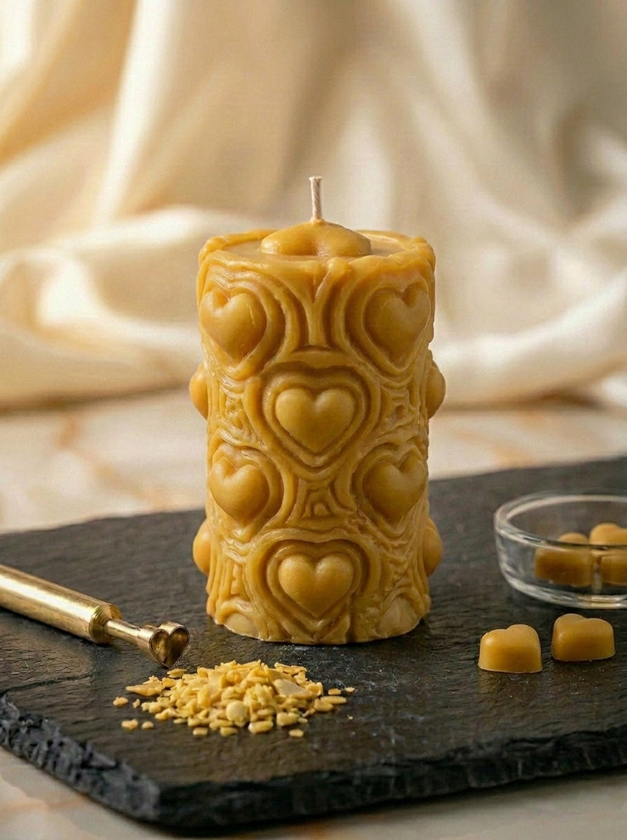candle with heart designs on a dark surface with honeycomb and 